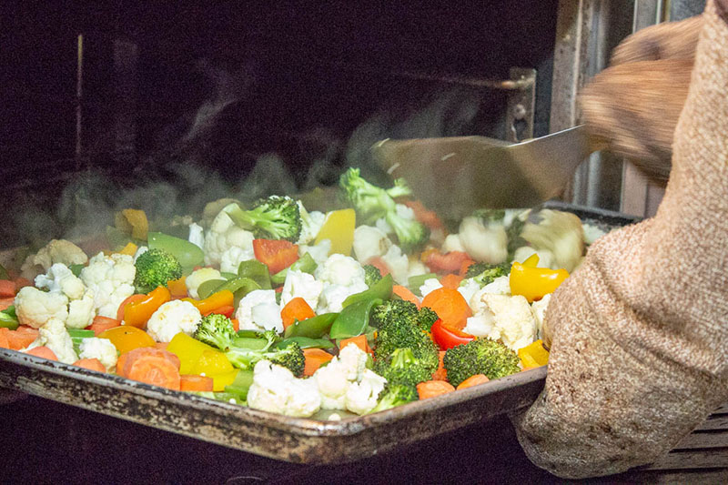 Mixed vegetables being cooked on a pan in the oven.
