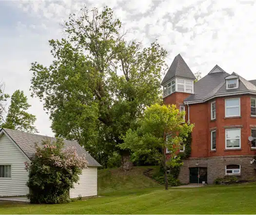 Exterior look at Newgate 180 addiction recovery building, with lots of open green space and trees.