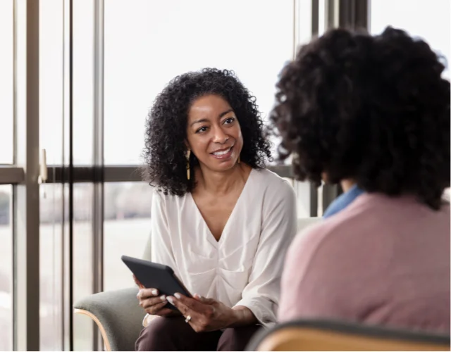 Two women speaking in a therapy session setting